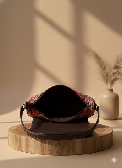 A bold crescent sling that blends heritage prints with modern elegance.